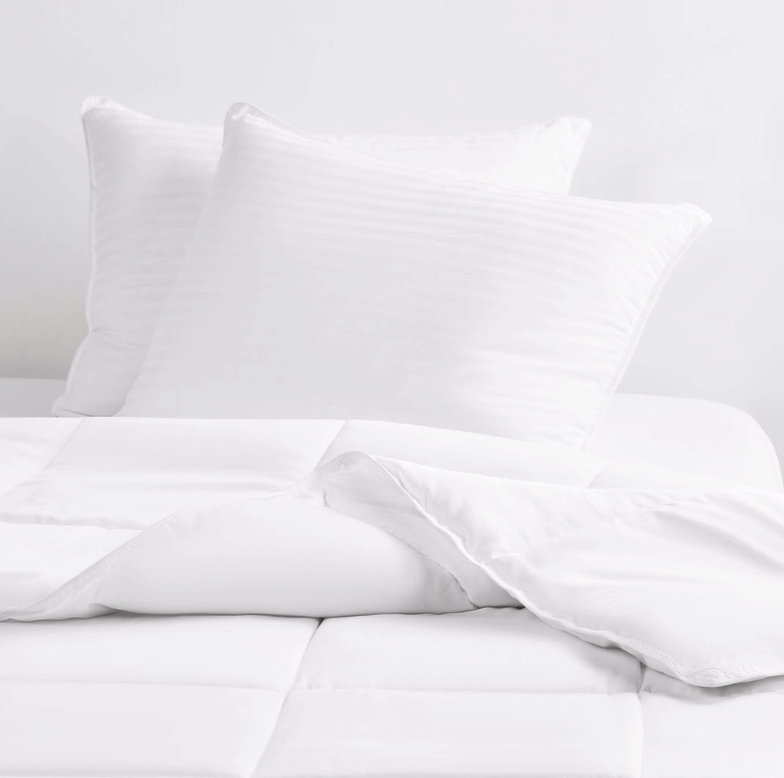 Clean cooling bed pillows and comforter on a bed